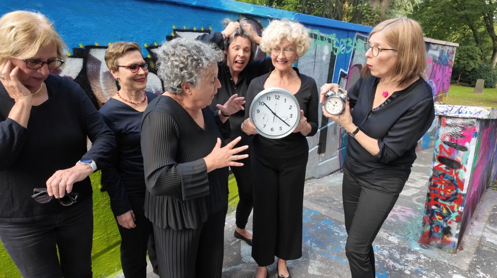 Sängerinnen der RuhrChoriFeen spielen humorvoll mit einer Wanduhr und einem Wecker