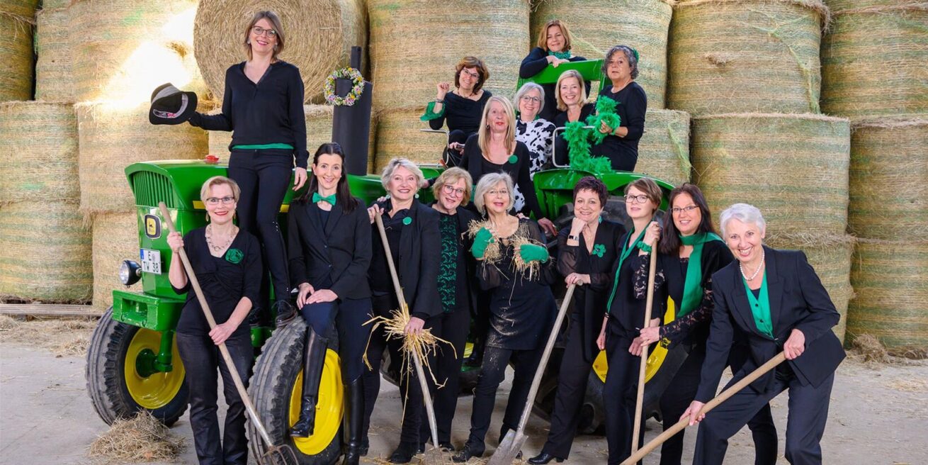 Historische Programmaufnahme des Chors vor Heuballen und einem grünen Traktor